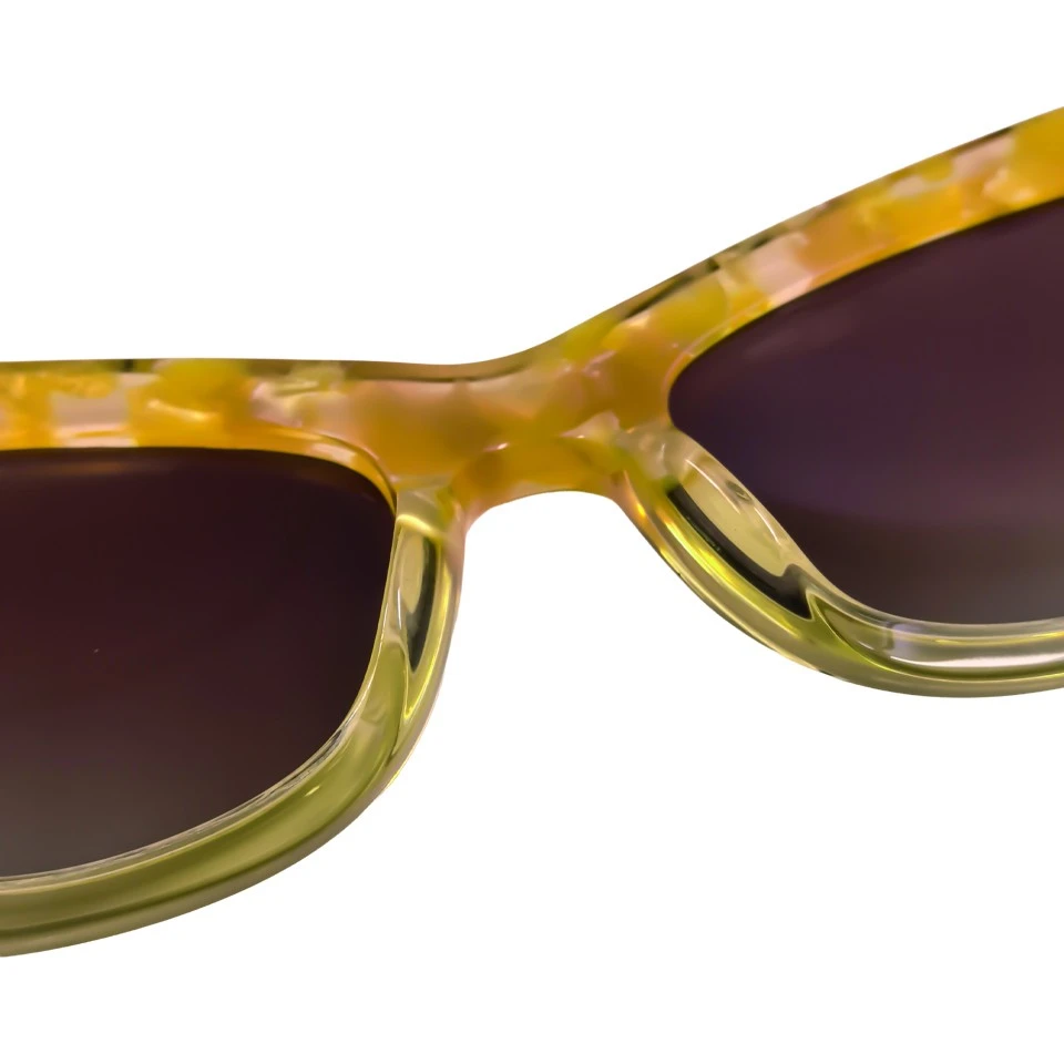 Close up of acetate frame texture and sharp cat eye silhouette on amber sunglasses